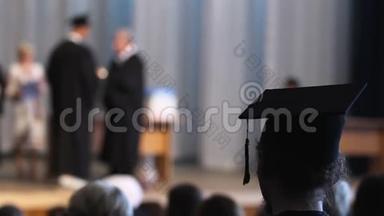 在<strong>毕业</strong>典礼上看着台上的学生，领取文凭的人